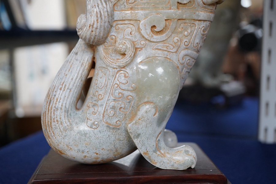 A large Chinese archaistic pale celadon and calcified jade rhyton, on a hardwood stand, 17.5cm high. Condition - fair to good.